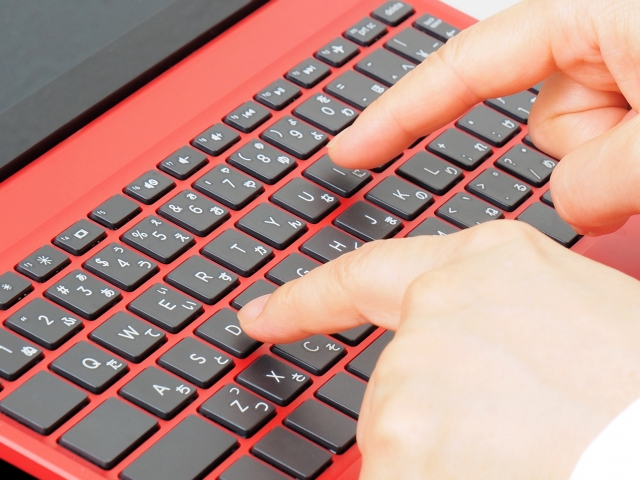 男性が人差し指だけでタイピングをしている手とキーボードの画像
