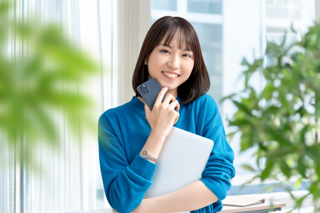 パソコンとスマホを持つ女性