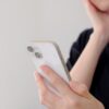 スマホを見つめながら考える女性