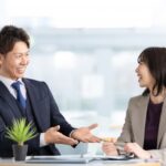 パソコンを前にして語る男女